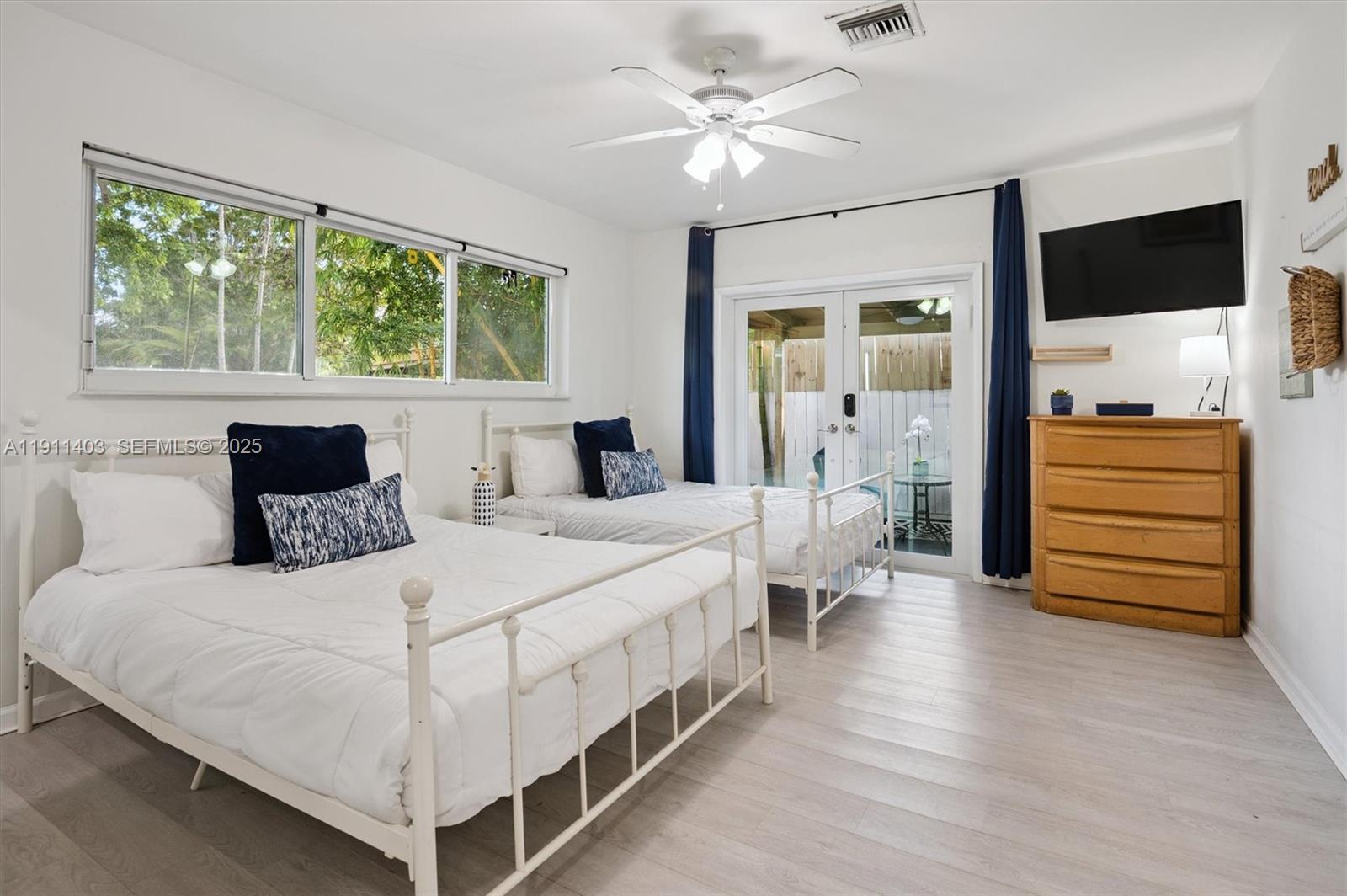 630 Northeast 175th Street Miami, FL 33162 - Photo 12 of 28 a bedroom with a large bed and a chandelier