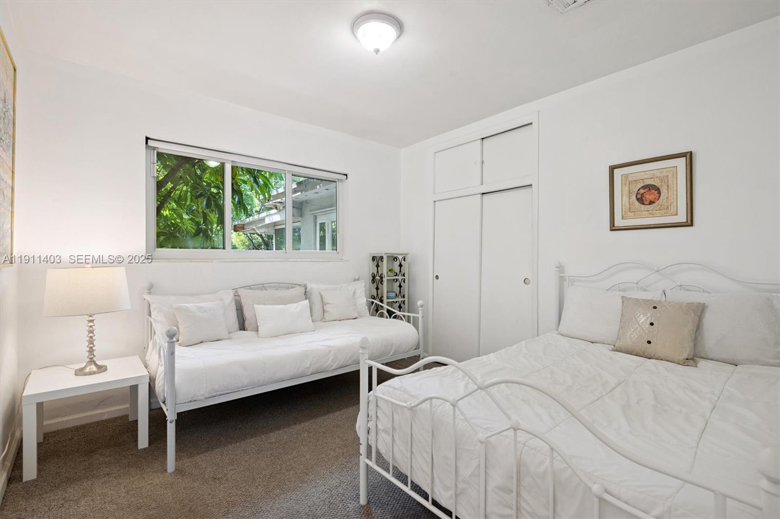 630 Northeast 175th Street Miami, FL 33162 - Photo 16 of 28 a bedroom with two beds and a large window