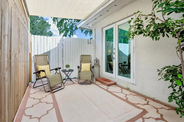 a view of a patio with table and chairs potted plants with wooden fence