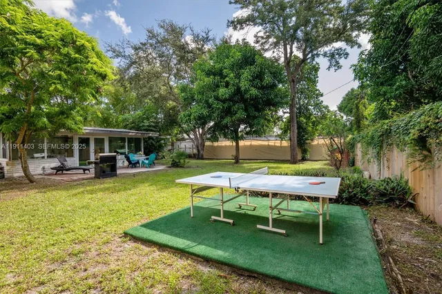 a white bench sitting in a yard with swimming pool and sitting area