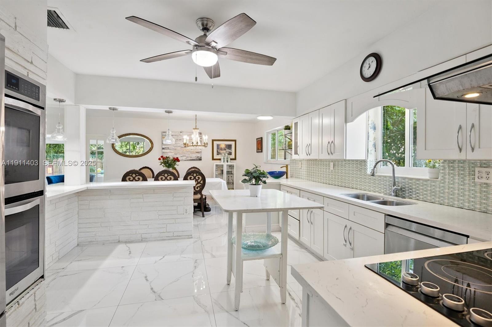 630 Northeast 175th Street Miami, FL 33162 - Photo 9 of 28 a large white kitchen with a large window