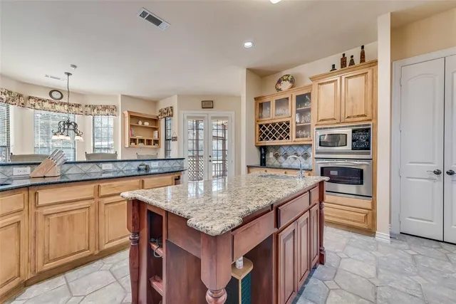 a kitchen with stainless steel appliances granite countertop a stove a sink and a refrigerator