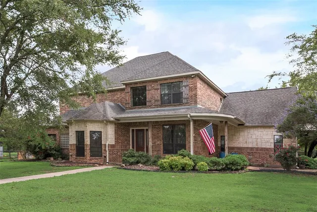 a front view of a house with a yard and trees