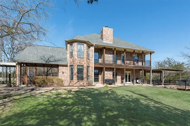 a view of a house with a big yard plants and large trees