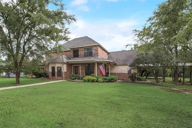 a view of a big house with a big yard and large trees
