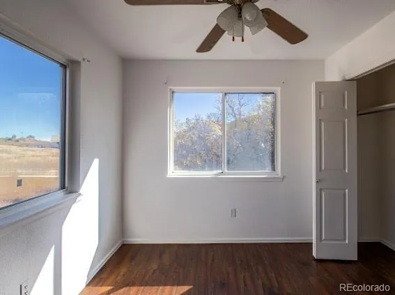 a view of a hallway with wooden floor and cabinet