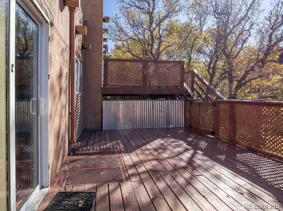 a view of backyard with wooden fence and large trees