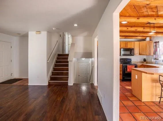 a view of a kitchen with wooden floor and electronic appliances
