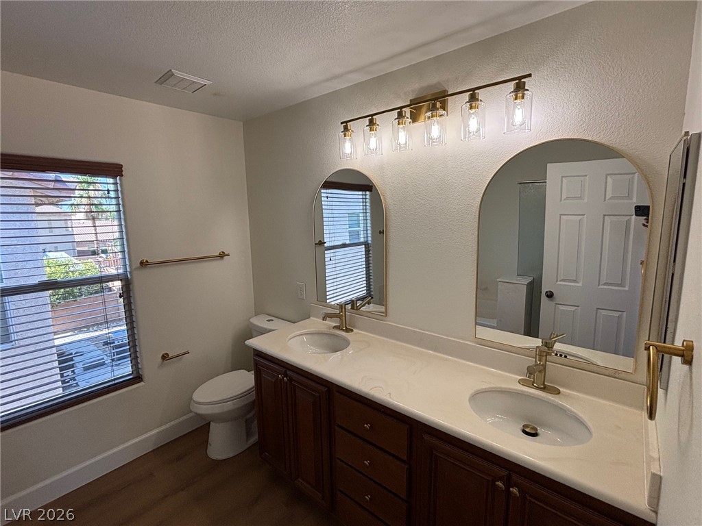 4900 Naff Ridge Drive Las Vegas, NV 89131 - Photo 12 of 21 Double vanities and modern gold fixtures elevate daily routines in this primary bathroom.