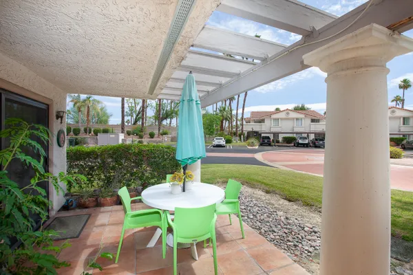 a view of a patio with table and chairs potted plants with wooden floor and fence