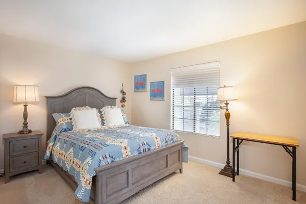 a bedroom with a bed a lamp and window