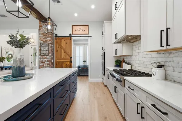 a living room with stainless steel appliances kitchen island granite countertop a stove and cabinets