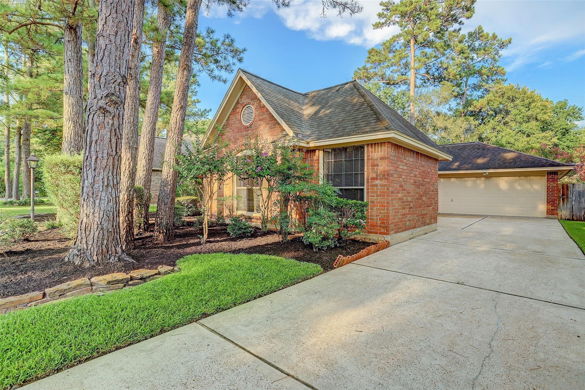 10 Heathstone Place The Woodlands, TX 77381 - Photo 1 of 27 Charming brick home nestled among mature trees, featuring a classic design, well-maintained front yard, spacious driveway, and two-car garage—perfect for those seeking a cozy, inviting setting.