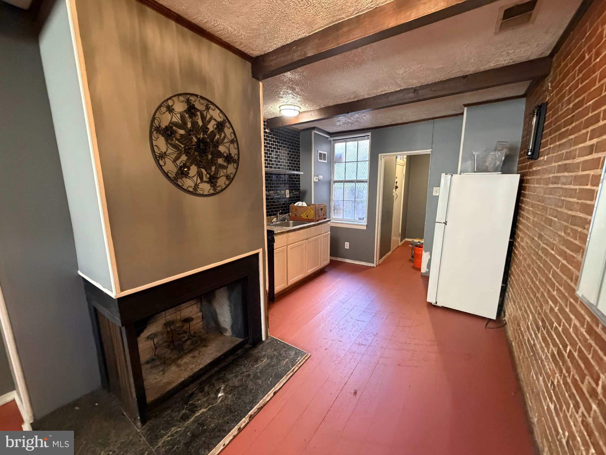 703 Tessier Street Baltimore, MD 21201 - Photo 4 of 12 a view of an empty room with wooden floor and a window