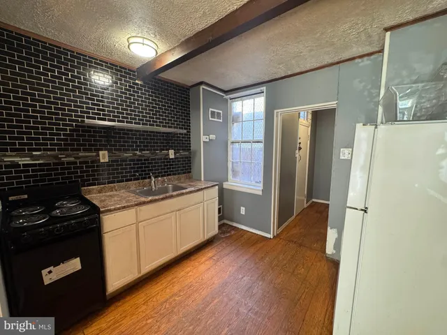 a kitchen with a sink a refrigerator and cabinets