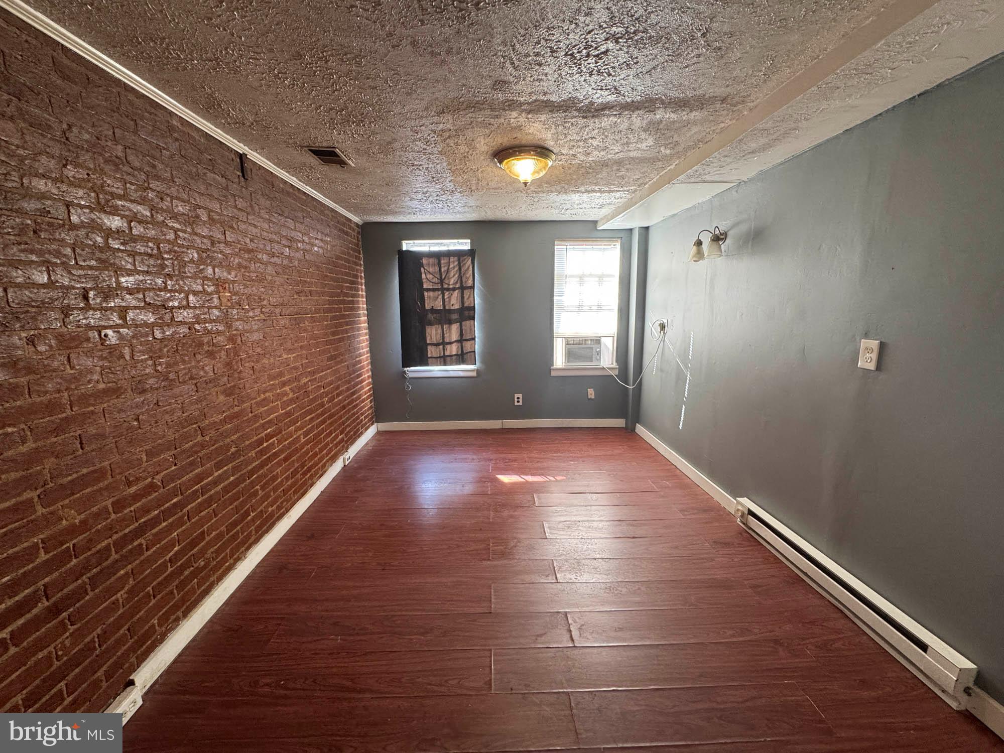 703 Tessier Street Baltimore, MD 21201 - Photo 6 of 11 a view of livingroom with hardwood floor and window