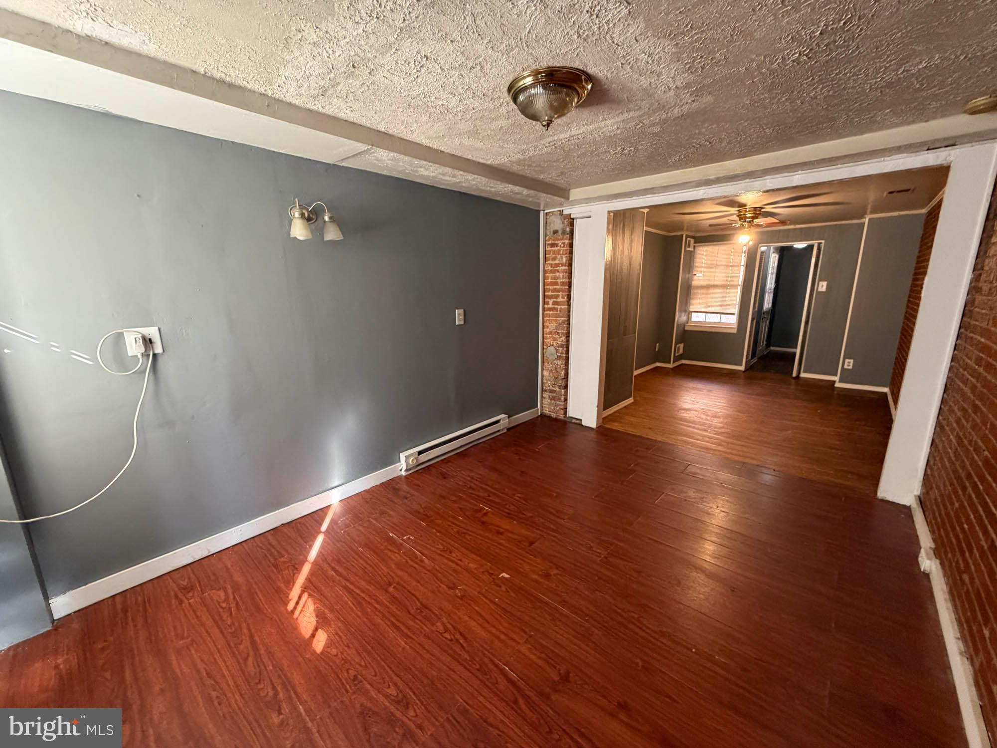 703 Tessier Street Baltimore, MD 21201 - Photo 7 of 12 a view of a livingroom with wooden floor and a ceiling fan