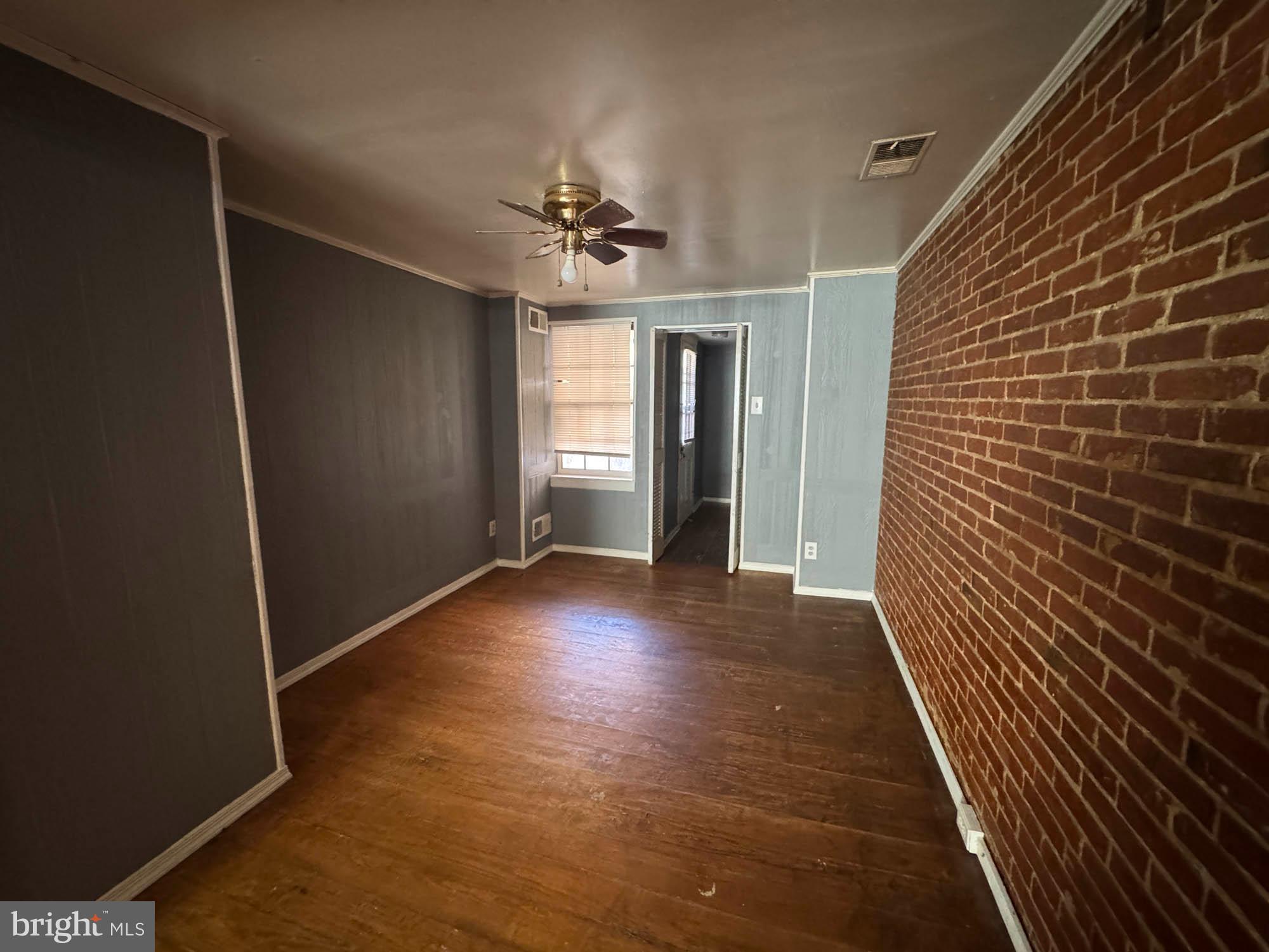 703 Tessier Street Baltimore, MD 21201 - Photo 7 of 11 a view of a hallway with wooden floor and chandelier