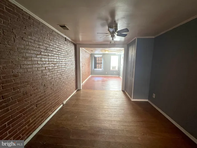 a view of a hallway with wooden floor and chandelier