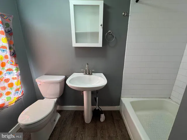 a bathroom with a sink a toilet a mirror and bathtub