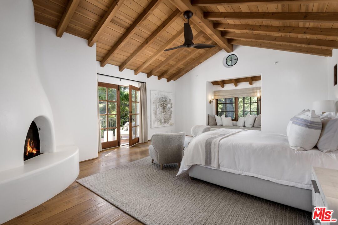 849 Ashley Road Montecito, CA 93108 - Photo 15 of 28 a bedroom with a bed a couch and large window with wooden floor
