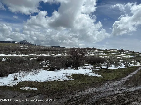 a view of a town of snow and covered with trees