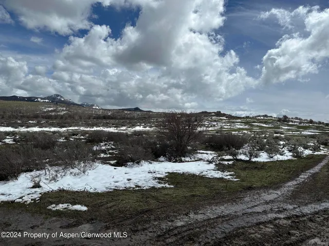 a view of a town of snow and covered with trees