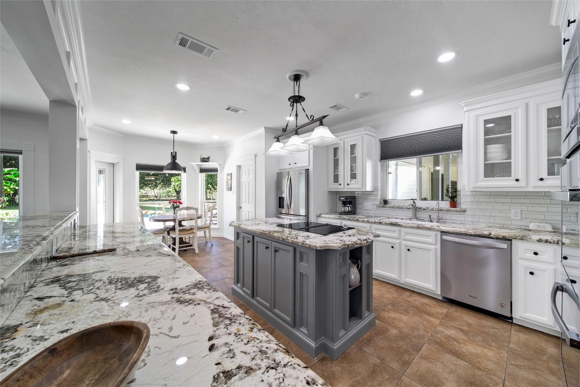 29919 Tudor Way Magnolia, TX 77355 - Photo 13 of 50 a large kitchen with kitchen island a sink a stove a dining table and chairs