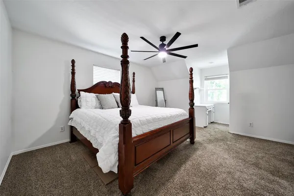 a bedroom with a bed and a ceiling fan