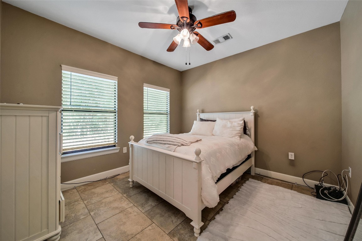 29919 Tudor Way Magnolia, TX 77355 - Photo 38 of 50 a bedroom with a bed and a chandelier