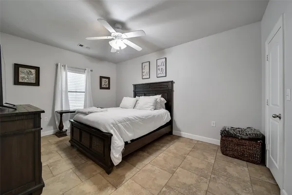 a spacious bedroom with a bed and a chandelier