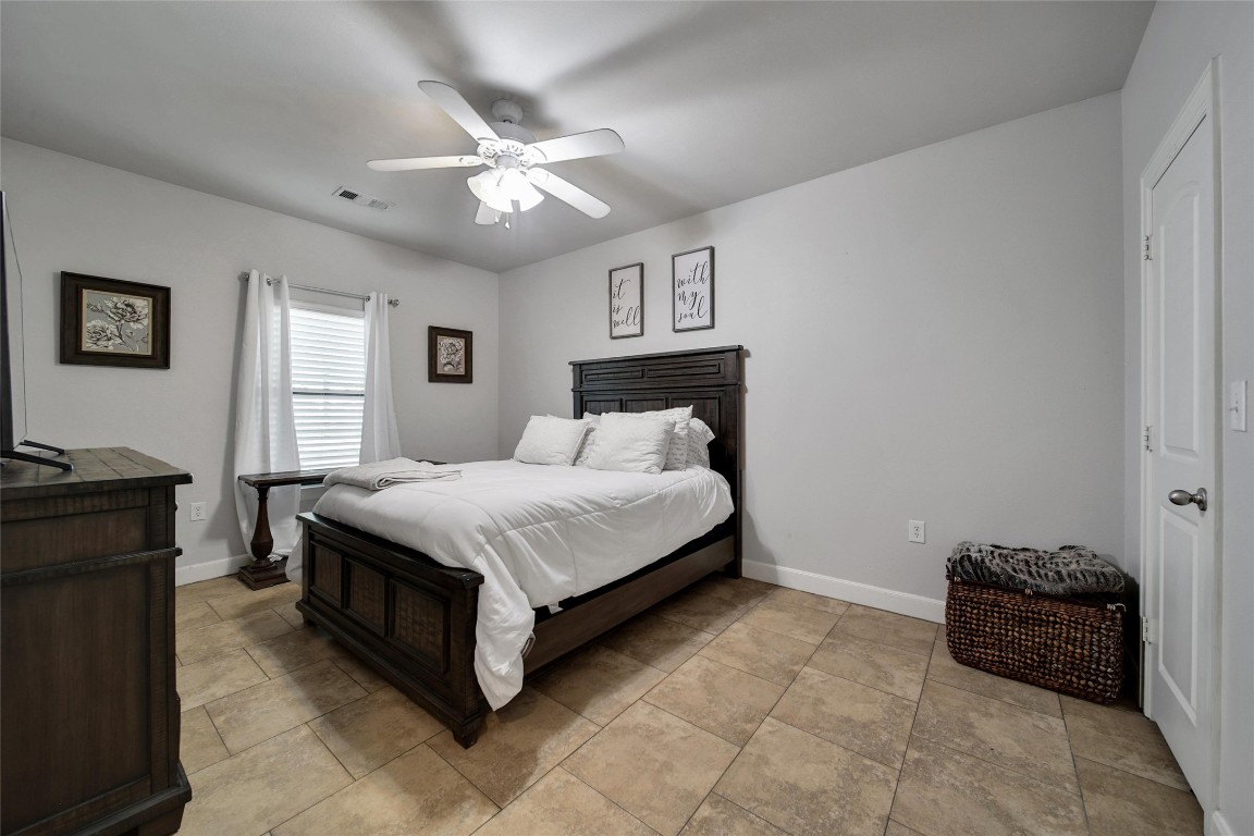 29919 Tudor Way Magnolia, TX 77355 - Photo 39 of 50 a spacious bedroom with a bed and a chandelier