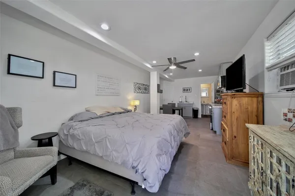 a spacious bedroom with a bed and a flat screen television