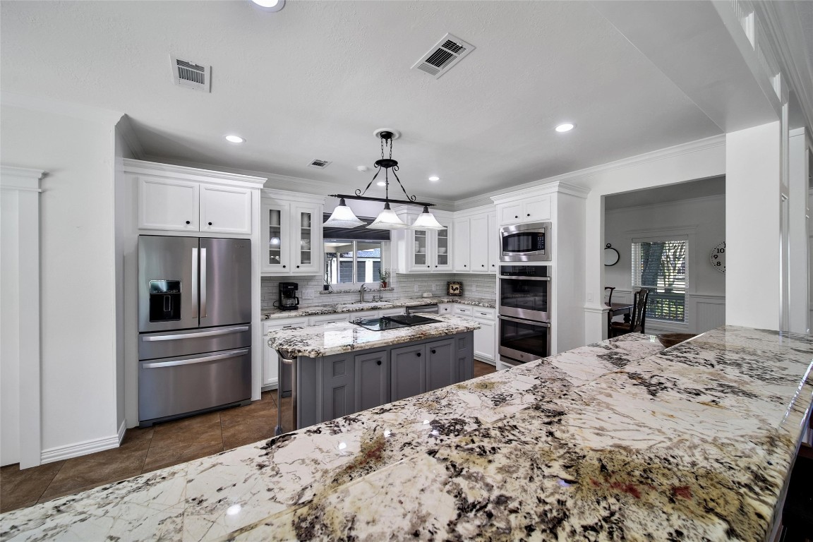 29919 Tudor Way Magnolia, TX 77355 - Photo 9 of 50 a kitchen with stainless steel appliances kitchen island granite countertop a refrigerator and a stove top oven