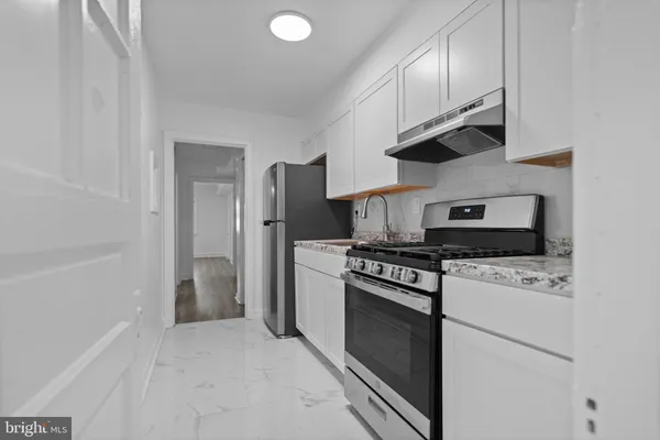 a kitchen with stainless steel appliances granite countertop a stove a refrigerator and a sink