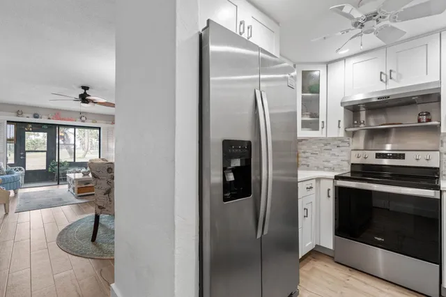 a kitchen with stainless steel appliances granite countertop a refrigerator a stove and a sink with cabinets