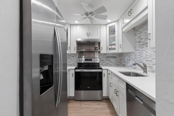 a kitchen with stainless steel appliances granite countertop a sink stove and refrigerator
