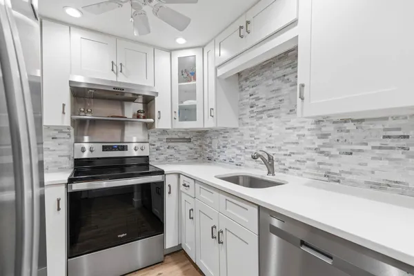 a kitchen with granite countertop a stove sink and cabinets