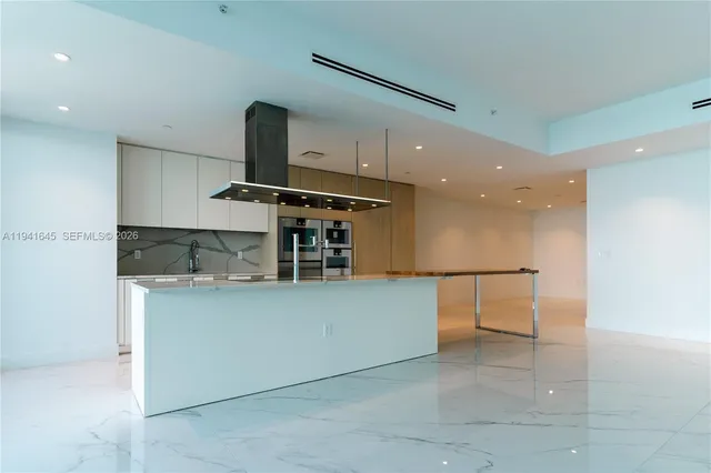 a kitchen with stainless steel appliances kitchen island a large counter top