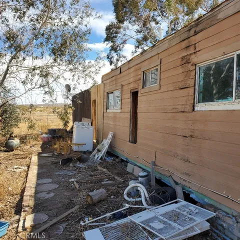 a backyard of a house with chairs and table
