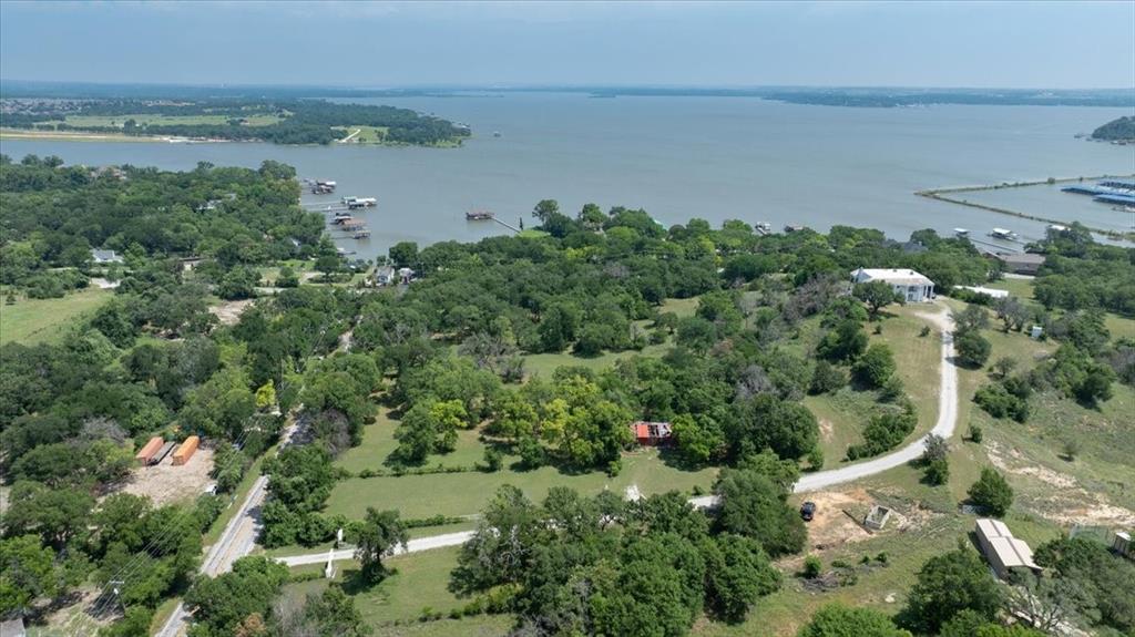an aerial view of a houses with outdoor space and trees all around