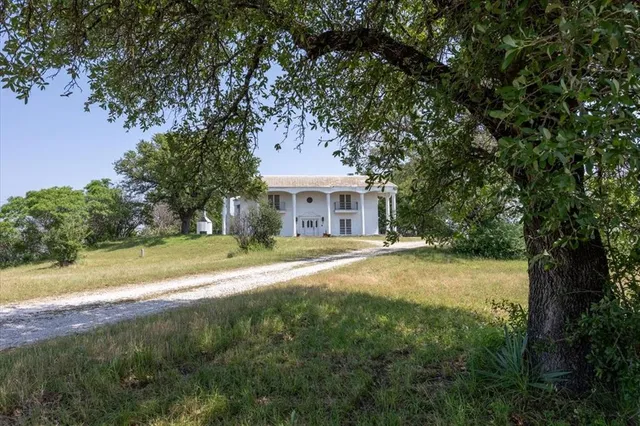 a front view of a house with yard and green space