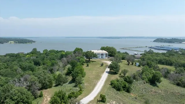 an aerial view of a houses with outdoor space and trees