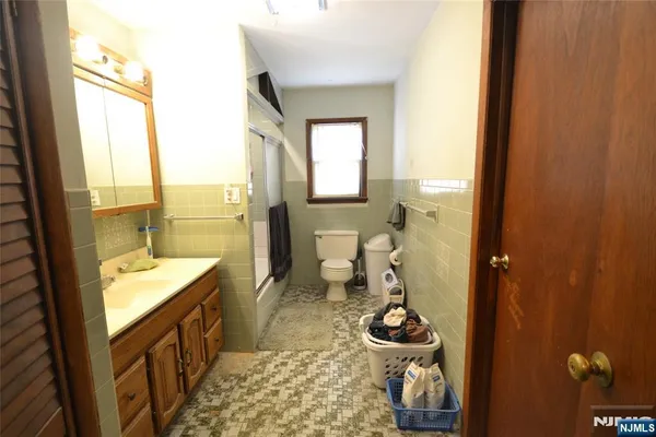 a bathroom with a granite countertop toilet a sink and shower