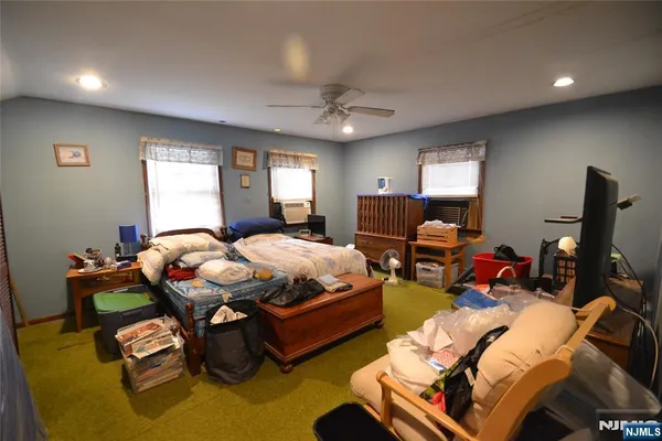 an empty room with windows and ceiling fan