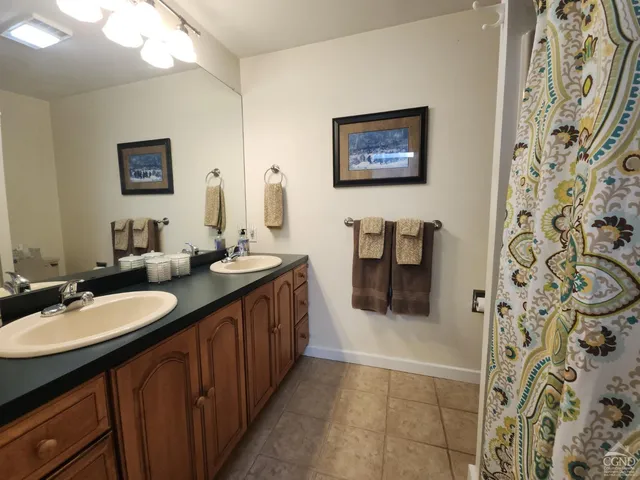 a bathroom with a double vanity sink and a mirror