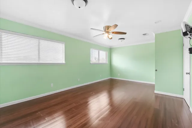 an empty room with wooden floor and window