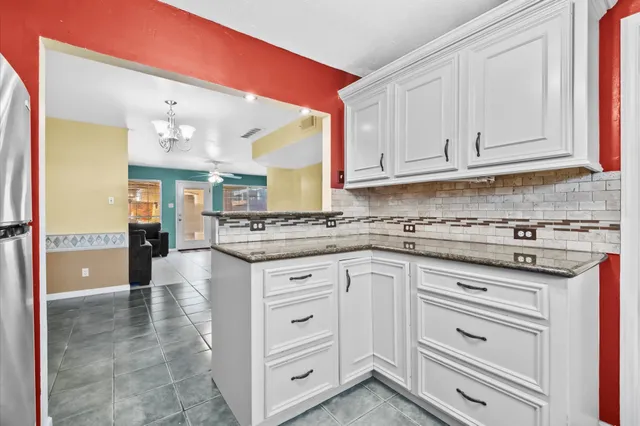 a kitchen with granite countertop white cabinets and white appliances