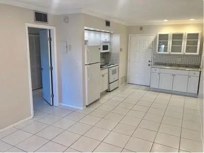 a kitchen with white cabinets a sink a window and stainless steel appliances