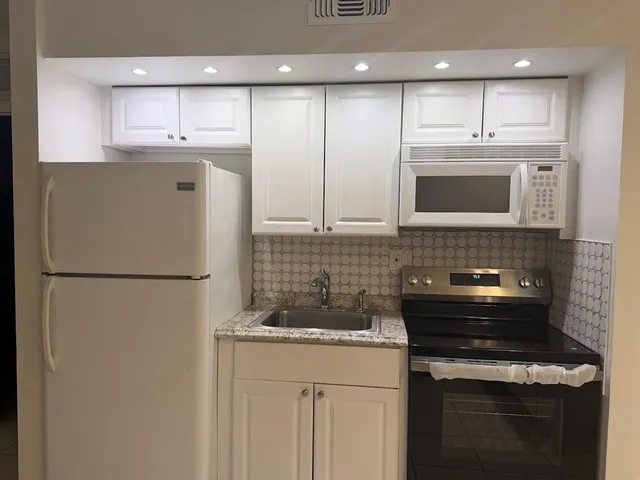a kitchen with stainless steel appliances a refrigerator sink and microwave